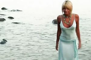 Blonde cutie Masha disrobes on a beach and shows her wonderful body