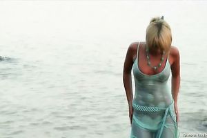 Blonde cutie Masha disrobes on a beach and shows her wonderful body