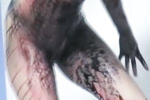 Curly-haired non-professional golden-haired smears her body with paint indoors