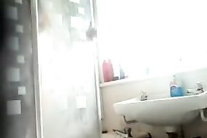 Slim dark brown beauty with tanned skin washes her body in shower