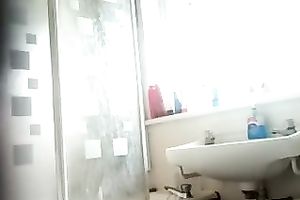 Slim dark brown beauty with tanned skin washes her body in shower
