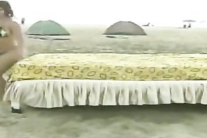 Playful non-professional lalin girl chicks on the beach jumping on a daybed