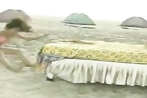 Playful non-professional lalin girl chicks on the beach jumping on a daybed
