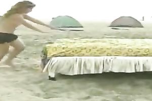 Playful non-professional lalin girl chicks on the beach jumping on a daybed