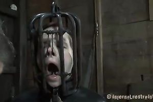 Brunette sweetheart wearing head cage receives her snatch and face hole screwed with a fake penis