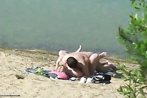 Amateur couple group-sex in the cowgirl position on a beach