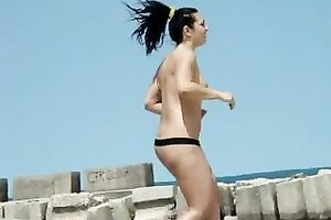 Hidden webcam scene with a topless brunette hair playing ball on a beach