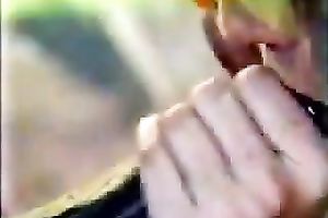 Lewd blond sucks a dark schlong outdoors and receives drilled in retro episode