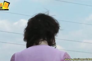 Short haired brunette bitch pisses aside the road and goes further