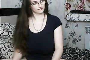 Long-haired milf wearing glasses strokes her wazoo in front of a web camera