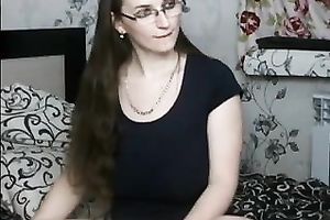 Long-haired milf wearing glasses strokes her wazoo in front of a web camera
