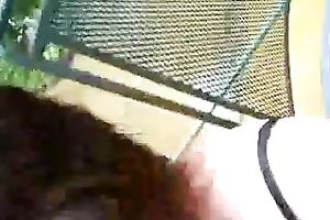 POV scene with a dark brown hussy engulfing my boner in the yard