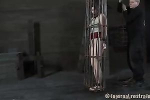 Redhead honey with steel mask on her head is captured in a cage