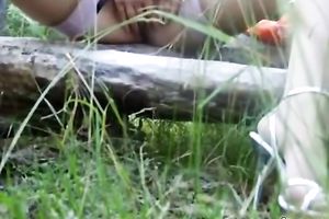 Blonde milf gives head to a dude in a forest and enjoys it from behind