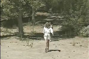 A blonde and a brunette hair go lesbo in a tent in retro porn movie