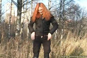 Stunning redhead sweetie in glasses pees on the autumn leaves