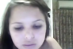 Brunette legal age teenager with big fake mounds fingers her twat in front of a web camera