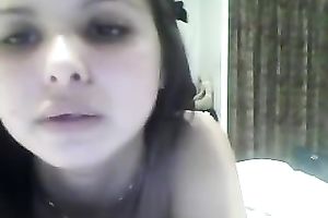 Brunette legal age teenager with big fake mounds fingers her twat in front of a web camera