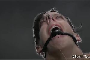 Wanton brunette hair chick with a gag in her face hole is tortured outdoors