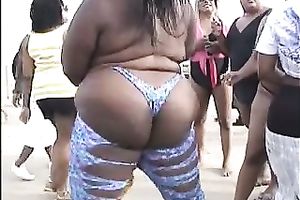 Lewd swarthy playgirl flashes her wazoo and slit on a beach