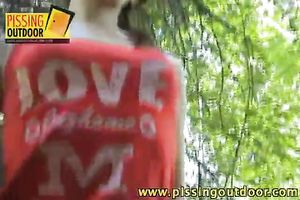 Cute teenage girl with pigtails makes water in the forest