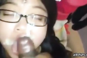 Four eyed Asian gal sucks her fuck buddy's 10-Pounder gently until this babe gets a facial