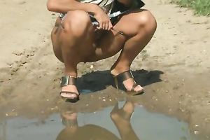 Blonde cutie with tanned skin pisses to the puddle