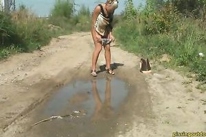 Blonde cutie with tanned skin pisses to the puddle