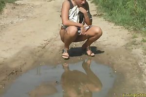 Blonde cutie with tanned skin pisses to the puddle