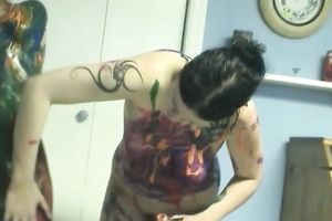 Two cute women smear each other's bodies with paints