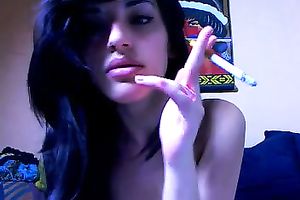 Sexy dark brown babe smokes a cig and shows her bald twat