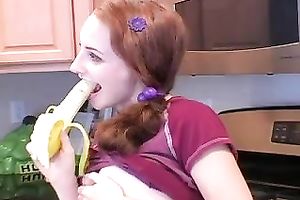 Redhead legal age teenager babe eats banana in the kitchen on livecam