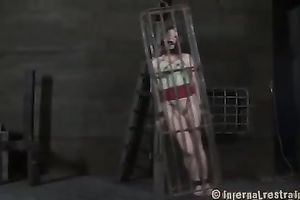 Slim white women in cage with a gag in throat is restrained and punished